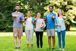 © Syda Productions - fitness, sport and healthy lifestyle concept - group of happy people with yoga mats showing thumbs up at park