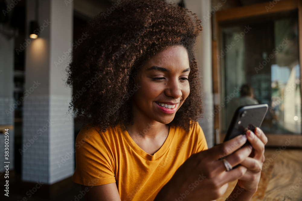 Beautiful smiling ethnic teenage customer female receiving text from ...