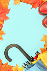 Wall Mural - Autumn leaves frame with red rubber boots and umbrella. Fall foliage banner. Weather forecast, rain. Bright orange and red maple tree leaves. Copy space on blue