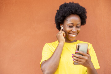 Canvas Print - Overexcited African-American female with afro hair using a modern smartphone checking social media