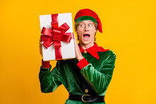 Portrait Of His He Nice Attractive Amazed Cheerful Cheery Funny Guy Elf Holding In Hands Giftbox Guessing What's Inside Having Fun Isolated Over Bright Vivid Shine Vibrant Yellow Color Background