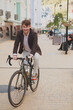 © mad_production - Vertical shot of a cheerful mature man enjoying riding his bike in the city