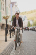 © mad_production - Vertical shot of happy mature businessman riding bicycle to work