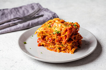 Wall Mural - Portion of traditional Italian lasagna with meat and cheese on gray plate. Italian cuisine concept.