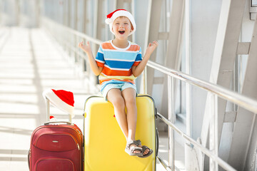 Wall Mural - Happy kid at the airport in christmas cap