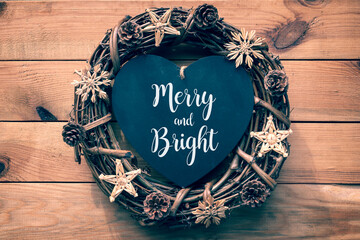 Wall Mural - Merry and Bright Christmas greeting card. Rustic Christmas wreath on wooden planks background