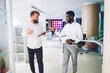 © BullRun - Content multiethnic male colleagues discussing project in modern office