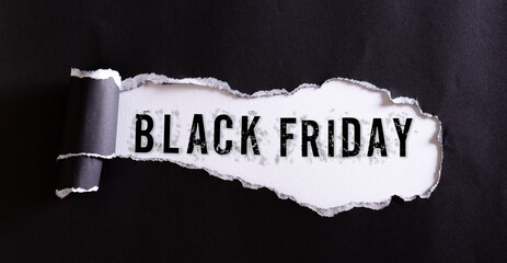 Wall Mural - Top view of black torn paper and the text Black Friday on a white background. Black Friday composition.