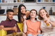 © LIGHTFIELD STUDIOS - joyful multicultural friends singing karaoke during party