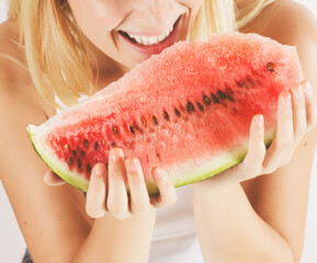 Beautiful blonde woman eating fresh watermelon