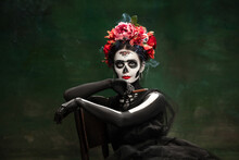 Smoke. Young Girl Like Santa Muerte Saint Death Or Sugar Skull With Bright Make-up. Portrait Isolated On Dark Green Studio Background With Copyspace. Celebrating Halloween Or Day Of The Dead.