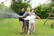© NVB Stocker - Asian family happy smiling and watering green cultivated plants with a garden hose at home. Happy family concept. 4 people father Mather sun daughter.