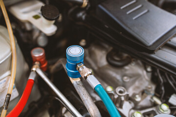 servicing car air conditioner in repair workshop with soft-focus and over light in the background