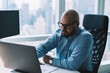 © BullRun - Focused man using laptop in modern workspace