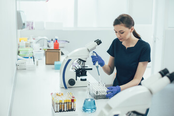 Careful medical worker using manual pipette in the laboratory