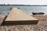 Fototapeta Pomosty - drewniany pomost i łódka nad jeziorem