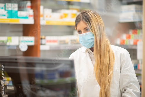 Fototapeta Masked cashier in a pharmacy, coronavirus concept
