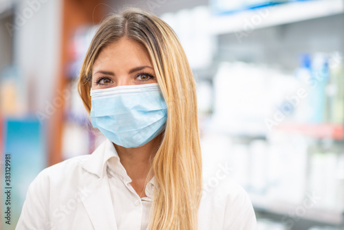 Fotografía Smiling pharmacist wearing covid coronavirus mask in her pharmacy