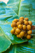 A bunch of longan branches on a background of green banana leaf. Vitamins, fruits, healthy foods