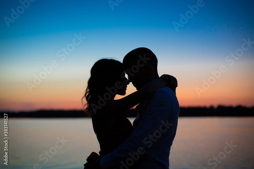 Fotografía Silhouettes of a couple in love romance at sunset