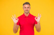 © be free - Satisfactory result. Happy man show double OK signs yellow background. Satisfied guy smile with satisfaction. Agreement and confirmation. Satisfactory solution