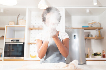 Woman having fun with flour in kitchen