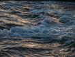 Close of shot of river water rippling and flowing golden light.