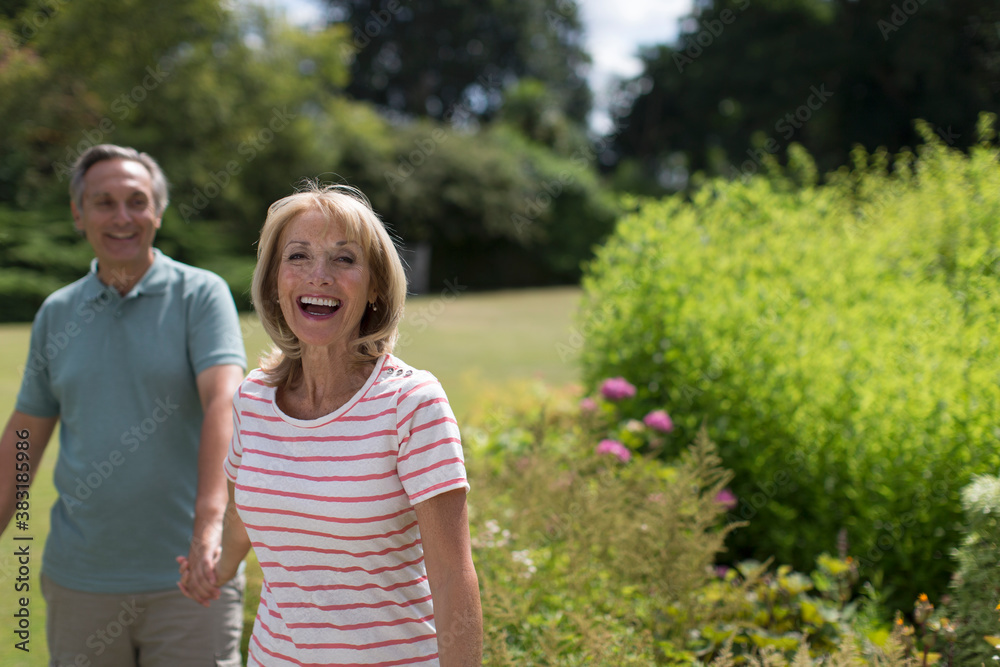 Portrait happy senior couple holding hands in sunny garden Stock Photo ...