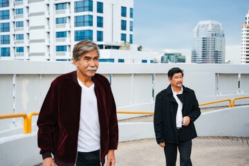 Wall Mural - Two senior business man walking outdoors in city.