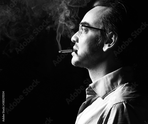 Fotografía Portrait of brutal strong man business shark in official shirt and glasses stands with cigarette in his mouth