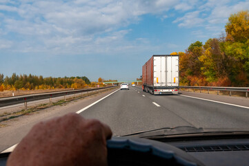 a truck driving on a highway on a bright autumn day