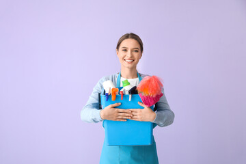 Young woman with cleaning supplies on color background