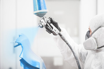 Wall Mural - Man sprays blue dye on the elements of the vehicle.