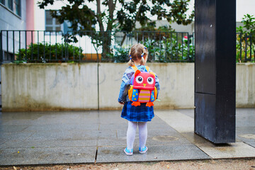 Wall Mural - Adorable toddler girl with funny backpack ready to go to daycare, kindergarten or school