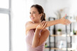 © Syda Productions - sport, fitness and healthy lifestyle concept - smiling young woman stretching arm at home
