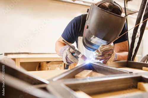 Fotografía Male in face mask welds with argon-arc welding