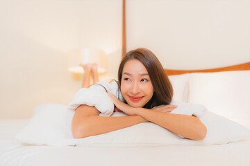 Wall Mural - Portrait beautiful young asian woman smile relax on bed in bedroom interior