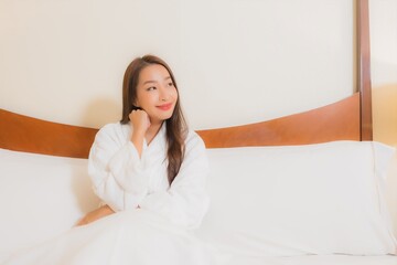 Wall Mural - Portrait beautiful young asian woman smile relax on bed in bedroom interior