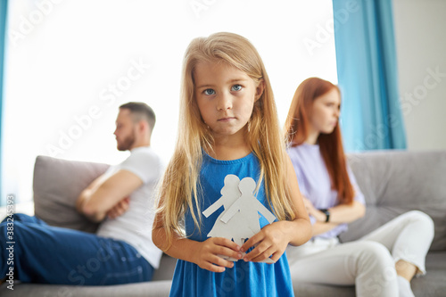 Fotografía sweet little caucasian child girl holding family picture drawing feeling upset a