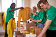 © alfa27 - young enthusiastic volunteers with donations for poor people, cardboard box with clothes for charity. kind people help poor, cases full of clothing for poor giving, social activity concept
