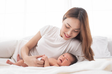 Canvas Print - woman and new born boy relax. mother breast feeding baby. family at home. happy mother and baby. young mother holding her newborn child. mom nursing baby. mother and baby child on a white bed.