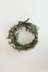 Wall Mural - Round wreath frame made of fir and eucalyptus branches on white background. Christmas / New Year celebration decoration. Holiday concept.