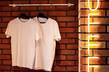 Wall Mural - White T-shirts hang on hangers. For a clothing brand.