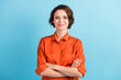 Leinwandbild Motiv Photo of attractive charming lady cute bobbed hairdo arms crossed self-confident person worker friendly smile good mood wear orange office shirt isolated blue color background
