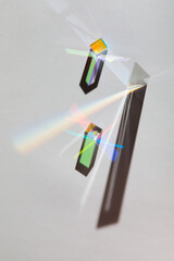 Glass geometric figures prisms with light diffraction of spectrum colors and complex reflection with trendy light and hard shadows on a white background