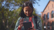 © nimito - Happy asian girl student with backpack using digital tablet standing outdoors school building
