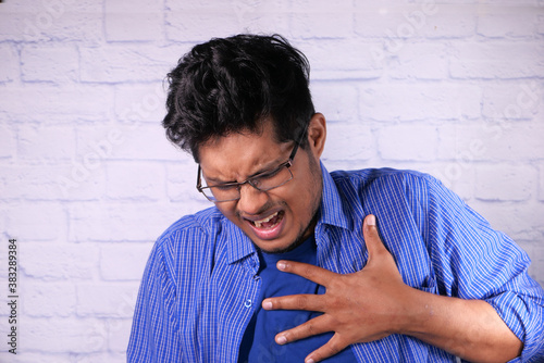 Cuadros en Lienzo young man suffering pain in heart and holding chest with hand