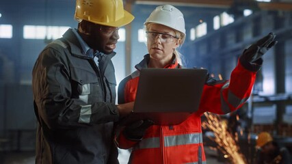 Poster - Two Heavy Industry Engineers Stand in Steel Metal Manufacturing Factory, Use Digital Tablet Computer and Have a Discussion. Black African American Industrial Specialist Talk to Female Technician.