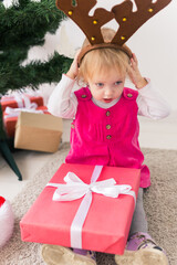 Wall Mural - Child holding Christmas gift. Kid having fun at home. Xmas winter holiday concept