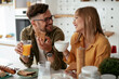 © JustLife - Young couple making sandwich at home. Loving couple enjoying in the kitchen.